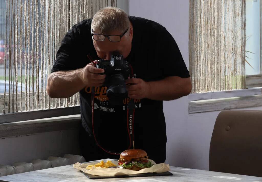 Fotografas fotografuoja burgerį